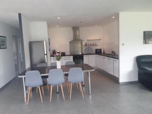 a kitchen with a table and four chairs in a kitchen at Villa familiale Bassin Arcachon in Salles