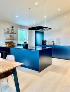 eine Küche mit blauen Schränken und einem Holztisch in der Unterkunft Villa Artic in Tromsø