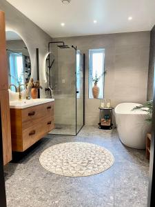 ein Bad mit einer Badewanne, einem Waschbecken und einer Dusche in der Unterkunft Villa Artic in Tromsø