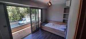 アルテミダにあるAmmos Artemis Apartmentsのベッド1台と大きな窓が備わる小さな客室です。 +34枚の写真