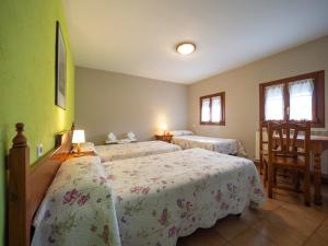 a bedroom with two beds and a table and chairs at Casa Forestal in Aínsa