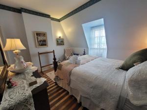 een slaapkamer met 2 bedden en een tafel met een lamp bij The Scotsman Inn in Pictou