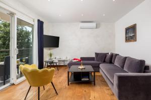 a living room with a gray couch and a yellow chair at Design Apartment Linda in Lovran