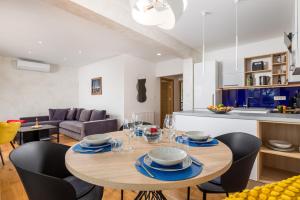 a kitchen and living room with a wooden table and chairs at Design Apartment Linda in Lovran