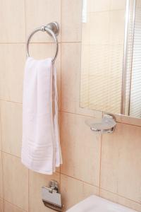 un bagno con un asciugamano bianco appeso a una parete di Blue Dream Poseidi a Possidi Altre 18 foto