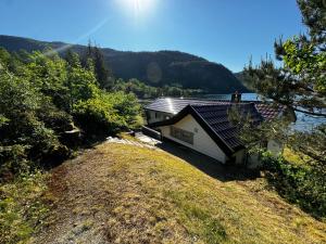 a house on a hill next to a body of water at Strandhytte nær preikestolen in Strand +13 photos