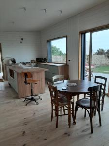 a kitchen with a table and chairs in a room at Maison en bois vue sur mer en Bretagne 5 couchages in Plogoff +13 photos