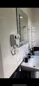 ein Badezimmer mit einem weißen Waschbecken und einem Spiegel in der Unterkunft HOTEL BOBROvski in Jassinja + 57 Fotos