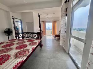 a bedroom with a bed and a large window at The Luxor Roof16 in Battaramulla