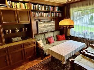 a living room with a couch and a table and books at Ferienhaus Moßhammer in Lofer