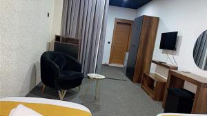 une chambre avec une chaise et une télévision dans l'établissement Nightview Erbil, à Erbil