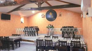 a dining room with tables and chairs and a clock on the wall at Casinha CB in Casteição
