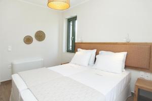 a white bed with white pillows in a bedroom at Anagallis Villas in Lefkada +56 photos