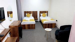アルビールにあるNightview Erbilのベッド2台とテレビが備わるホテルルームです。