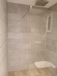 a bathroom with a glass shower with a toilet at Departamento Los Sauces in Macachín
