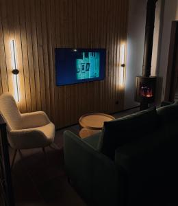 een woonkamer met een bank, een stoel en een televisie bij Siilihouse in Padise