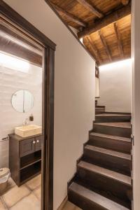 a bathroom with a staircase with a sink and a toilet at La Botica in Albarracín