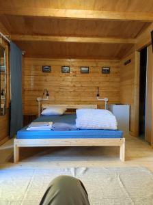 uma cama num quarto com uma parede de madeira em Parque de Campismo de Fão em Fão