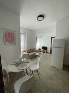 a living room with a table and chairs and a couch at Melivia apartments (2) in Ierissos