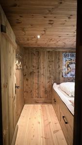 Liaplassen Mountain Chalet - Beitostølen في بيتوستول: غرفة خشبية مع سرير وأرضية خشبية
