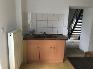 a kitchen with a sink next to a staircase at Logis cosy in Montbéliard +16 photos