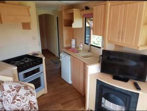 a small kitchen with a stove and a microwave at Superdomkikarwia in Karwieńskie Błoto Pierwsze