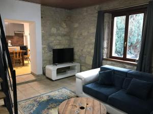 a living room with a blue couch and a tv at Logis cosy in Montbéliard