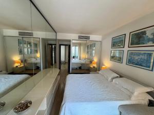 um quarto com 2 camas e um espelho grande em Elegant Monaco Port de Fontvieille apartment with Garden View and Pool Access em Monte Carlo