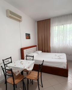 - une chambre avec un lit, une table et des chaises dans l'établissement H&A Guest House, à Golem