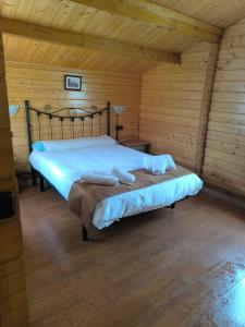 a bedroom with a bed in a wooden room at Cabañas Miraduero in Aldeadávila de la Ribera