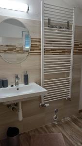 La salle de bains est pourvue d'un lavabo et d'un miroir. dans l'établissement Penzion Villa Marion, à Mariánské Lázně