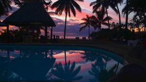 un reflejo de una puesta de sol en una piscina en Aquarius On The Beach, en Nadi