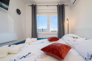 a bedroom with a large bed with red and white pillows at Ante room's in Trogir