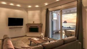 a living room with a couch and a view of the ocean at Villa Marisol in Pollonia