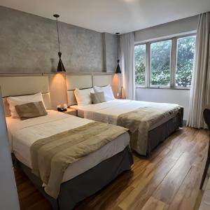 two beds in a hotel room with two lamps at Real Palace Hotel in Rio de Janeiro