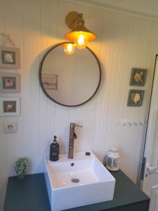 ein Badezimmer mit einem weißen Waschbecken und einem Spiegel in der Unterkunft Quinta da Maínha - Charming Houses in Braga
