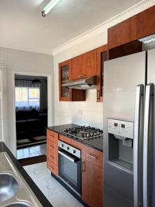 a kitchen with a stainless steel refrigerator and a stove at Nid De Chateau in Harare