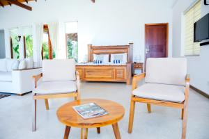 a living room with two chairs and a table at Aryan Beach Villa in Wadduwa