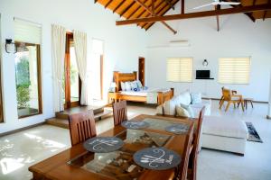 uma sala de estar com uma mesa e um sofá em Aryan Beach Villa em Wadduwa