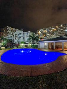 a large blue pool in front of a building at night at North beach summer sands holiday apartment in Durban