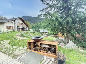 an outdoor grill in a yard next to a house at CHALET DON PAPA in Saint-Martin-Vésubie