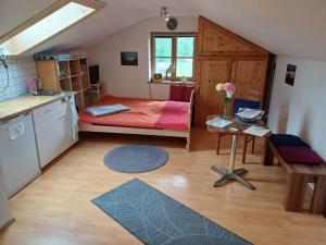 a small room with a bed and a kitchen at Apartment Moosblick zwischen Bergen und See in Benediktbeuern