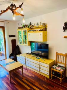 a living room with a tv on a dresser at El refugio de la ardilla, apartamento Canfranc-estacion in Canfranc-Estación