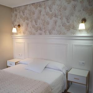 sypialnia z łóżkiem i dwie szafki nocne obok w obiekcie Hotel El Pescador w mieście Tazones