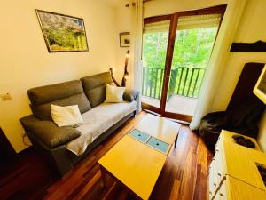 a living room with a couch and a table at El refugio de la ardilla, apartamento Canfranc-estacion in Canfranc-Estación