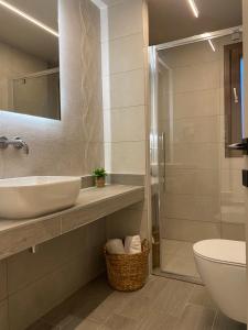y baño con lavabo, aseo y ducha. en Αura Luxury Apartments, en Ierissos