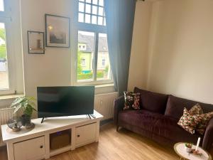 a living room with a couch and a flat screen tv at Five O - FeelGood-Apartment Goethe in Perleberg