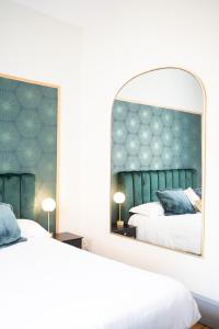 um quarto com 2 camas e um espelho grande em Villa Vichéia - Appartement 24 em Vichy