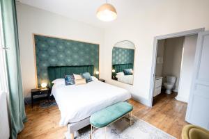 um quarto com uma cama grande e um espelho em Villa Vichéia - Appartement 24 em Vichy