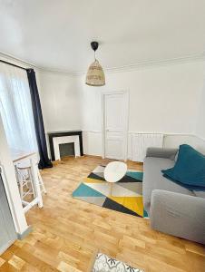 a living room with a couch and a table at Charmant T2 cosy et lumineux proche métro in Pantin